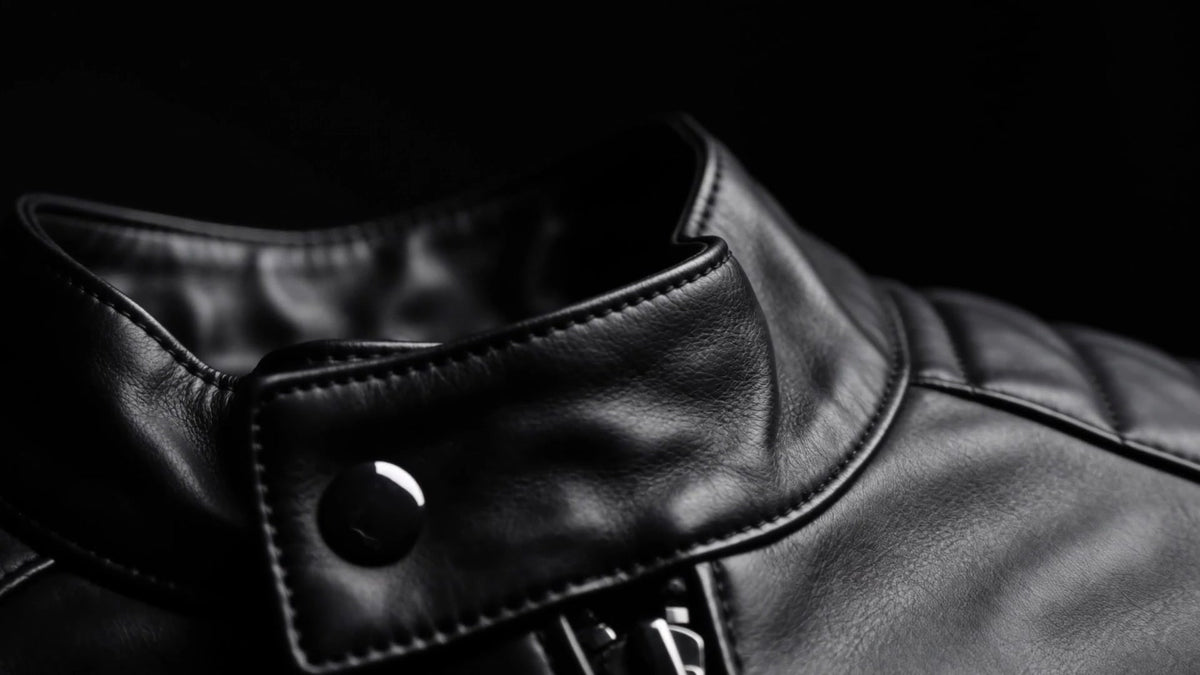 Close-up of the collar and press stud of a black leather jacket